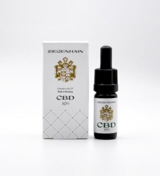 Eine kleine schwarze Flasche Ziegenhain CBD 10% Öl mit einer Pipette steht neben der weißen Kartonverpackung. Auf der Schachtel steht der Markenname „Ziegenhain“ und ein goldenes Emblem mit der Produktbeschreibung „Volksprsium Bio-Öl Made in Germany“ und „CBD 10%“.